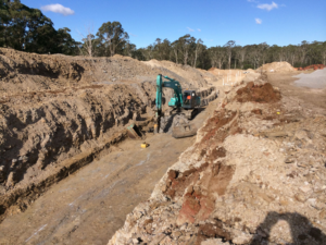 Excavator in wide trench